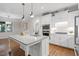 Bright kitchen with a large island, white cabinets, stainless steel appliances, and hardwood floors at 715 Kimbrough St, Raleigh, NC 27608