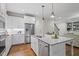 Well-lit kitchen featuring a large island with a sink, stainless steel appliances, and white cabinetry at 715 Kimbrough St, Raleigh, NC 27608