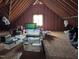 Unfinished attic with storage containers, exposed rafters, and window at 7401 Walnut Grove Ln, Zebulon, NC 27597