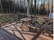 Back deck with metal table and chairs surrounded by a wooded, natural landscape at 7401 Walnut Grove Ln, Zebulon, NC 27597