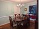 Formal dining room with hardwood floors, chandelier, and view into the adjacent living area at 7401 Walnut Grove Ln, Zebulon, NC 27597