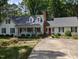 Inviting white home with a red front door, dormer windows, landscaping, and a spacious driveway at 7401 Walnut Grove Ln, Zebulon, NC 27597