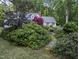 Scenic view of a home surrounded by lush greenery and a stone pathway leading to the entrance at 7401 Walnut Grove Ln, Zebulon, NC 27597
