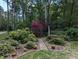 Well-manicured garden featuring a variety of plants, flowering shrubs, and a charming brick pathway at 7401 Walnut Grove Ln, Zebulon, NC 27597