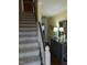 Inviting hallway featuring carpeted stairs, a gray accent table with lamps, and neutral wall colors at 7401 Walnut Grove Ln, Zebulon, NC 27597