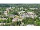 Aerial view showcasing a neighborhood with a mix of residential and commercial buildings surrounded by lush greenery at 831 S White St, Wake Forest, NC 27587