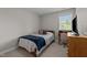 Bright bedroom with striped bedding, wood furniture, and natural light from the window at 831 S White St, Wake Forest, NC 27587