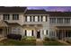 Charming townhome featuring gray siding, black shutters, a cozy front porch, and an American flag at 831 S White St, Wake Forest, NC 27587