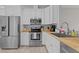 Bright kitchen featuring stainless steel appliances, white cabinetry, and butcher block countertops at 831 S White St, Wake Forest, NC 27587