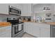 Bright kitchen features stainless steel appliances, wood countertops, and gray tile backsplash at 831 S White St, Wake Forest, NC 27587