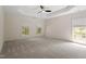 Spacious bedroom with natural light, neutral carpeting, and a tray ceiling with fan at 102 Downing Forest Pl, Cary, NC 27519