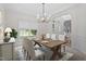 This dining room features a modern chandelier, light walls, and a decorative rug underneath the wooden table at 102 Downing Forest Pl, Cary, NC 27519