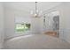 An empty dining room featuring chair railing, large window, and a modern chandelier ready for your personal touch at 102 Downing Forest Pl, Cary, NC 27519