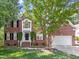 Charming two-story brick home featuring a manicured lawn, symmetrical design, and attached two car garage at 102 Downing Forest Pl, Cary, NC 27519