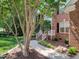 Inviting front entrance of a brick home, framed by mature landscaping and a well-maintained walkway at 102 Downing Forest Pl, Cary, NC 27519