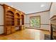Warm home office featuring hardwood floors, custom built-in shelving, and a neutral color palette at 102 Downing Forest Pl, Cary, NC 27519