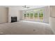 Bright living room with a fireplace, ceiling fan, and many large windows overlooking the backyard at 102 Downing Forest Pl, Cary, NC 27519