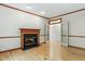 Cozy living room with hardwood floors, fireplace with marble surround, and access to another room through glass doors at 102 Downing Forest Pl, Cary, NC 27519