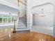 Open-concept living room with hardwood floors, staircase, carpeted living room and adjacent dining area at 102 Downing Forest Pl, Cary, NC 27519