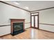 Bright living room featuring hardwood floors, a fireplace, and wood-trimmed doorway at 102 Downing Forest Pl, Cary, NC 27519