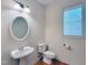 Powder room with pedestal sink, toilet, wood flooring, and natural light at 102 Downing Forest Pl, Cary, NC 27519
