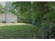 Expansive backyard with green grass, mature trees, and the house in the background at 103 Westview Dr # Apt K, Carrboro, NC 27510