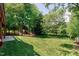 Spacious backyard with lush green lawn, mature trees, and a metal fence at 105 Bardsey Ct, Cary, NC 27513