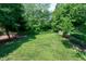 Lush green backyard with mature trees and metal fencing offering privacy at 105 Bardsey Ct, Cary, NC 27513