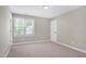 Bedroom featuring neutral carpet and walls, a window with blinds, and a white door at 105 Bardsey Ct, Cary, NC 27513