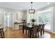 Bright dining room features a modern chandelier, wood floors, table with seating for six, and access to outdoor deck at 105 Bardsey Ct, Cary, NC 27513