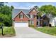 Well maintained brick home with a two car garage, mature trees, and a lush green lawn at 105 Bardsey Ct, Cary, NC 27513