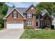 Stately brick home featuring manicured lawn, two car garage, and classic architectural details at 105 Bardsey Ct, Cary, NC 27513