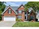 Charming brick home featuring manicured lawn, two-car garage, and traditional architectural details at 105 Bardsey Ct, Cary, NC 27513
