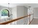 Hallway with wood and white railing, light walls, view of a big arched window at 105 Bardsey Ct, Cary, NC 27513