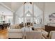 Spacious living room features vaulted ceilings, fireplace, multiple windows, hardwood floors, and flows into the dining room at 105 Bardsey Ct, Cary, NC 27513