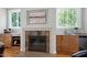 Living room features a fireplace with stone surround, custom cabinetry, hardwood floors and view of the backyard at 105 Bardsey Ct, Cary, NC 27513