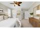 Bright main bedroom features a ceiling fan, neutral walls, and ensuite bathroom with closet at 105 Bardsey Ct, Cary, NC 27513