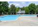 A sunny community pool with diving board, tables, chairs, and umbrellas at 105 Bardsey Ct, Cary, NC 27513