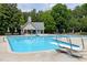 Community pool with diving board, lounge chairs, tables, umbrellas, and trees at 105 Bardsey Ct, Cary, NC 27513
