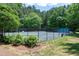 A full tennis court surrounded by black chain link fence and mature trees provides hours of fun and exercise at 105 Bardsey Ct, Cary, NC 27513