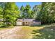 Charming single-story home featuring a one car garage and a gravel driveway, all surrounded by lush trees at 106 Blackfoot Dr, Louisburg, NC 27549