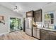 This well-lit kitchen features stainless steel appliances, dark wood cabinetry, and a view to an outdoor patio at 106 Blackfoot Dr, Louisburg, NC 27549