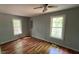 Spacious bedroom with hardwood floors, fan, and natural light from the two bright windows at 108 Horseman Dr, Louisburg, NC 27549