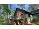 Charming home featuring a rustic exterior with wooden stairs, nestled among lush trees at 108 Horseman Dr, Louisburg, NC 27549
