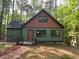Charming home featuring a rustic exterior with green and brown accents, nestled among lush trees at 108 Horseman Dr, Louisburg, NC 27549