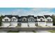 A row of new townhomes featuring varying neutral colors, modern garages, and well-maintained lawns at 108 Malbec Dr, Chapel Hill, NC 27516