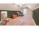 Large bonus room featuring carpet, walls with wainscotting, and a rocking chair at 11 Bridgeport Dr, Durham, NC 27713