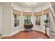 Breakfast nook with three windows, patterned window treatments, and a wooden table on brick floor at 11 Bridgeport Dr, Durham, NC 27713
