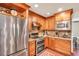 Spacious kitchen featuring wood cabinets, granite countertops, stainless steel appliances, and brick flooring at 11 Bridgeport Dr, Durham, NC 27713