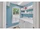Well-lit laundry room with a window, white shelving, and washer and dryer units at 11 Bridgeport Dr, Durham, NC 27713